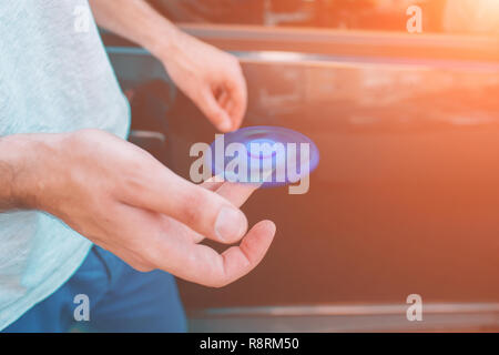 Young man holding et jouer avec fidget spinner. Banque D'Images