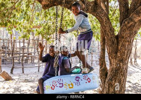 Des écoliers africains sur balançoire pneu smiling, Kariba Sud l'école primaire, la Zambie Banque D'Images