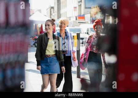 Les jeunes femmes amis marchant sur un trottoir urbain Banque D'Images