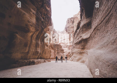 Siq, l'encoche étroite-canyon qui sert de couloir d'entrée à la ville cachée de Petra, Jordanie, photographié avec des touristes à pied. UNESCO World Sa Banque D'Images