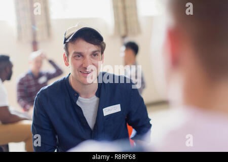 L'homme souriant à l'écoute dans la thérapie de groupe Banque D'Images