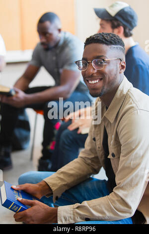 Portrait of smiling man holding bible en groupe de prière Banque D'Images