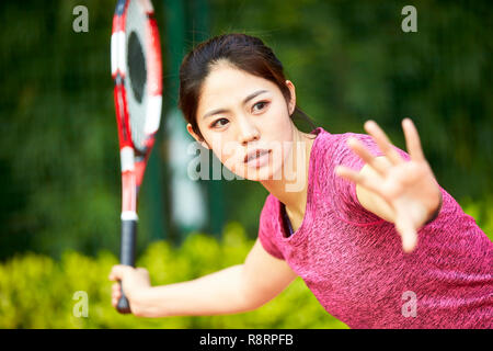 Young Asian woman tennis player hitting ball avec forehand Banque D'Images