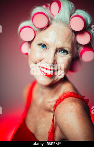 Portrait souriant, confiant senior woman with hair in curlers Banque D'Images