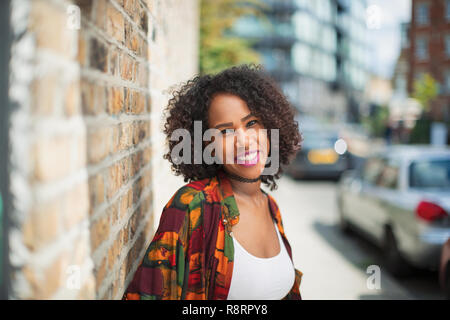 Portrait heureux, confiants jeune femme sur un trottoir urbain Banque D'Images