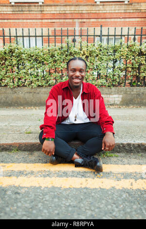 Portrait souriant, confiant teenage boy sur trottoir urbain Banque D'Images