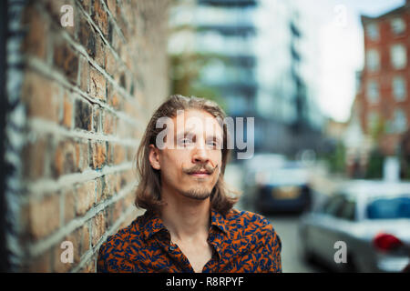 Portrait jeune homme confiant sur trottoir urbain hipster Banque D'Images