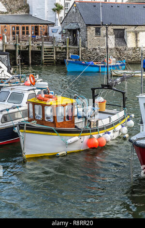 Bleu, blanc et jaune bateaux de pêche amarrés dans le port historique de Polperro à Cornwall, UK Banque D'Images