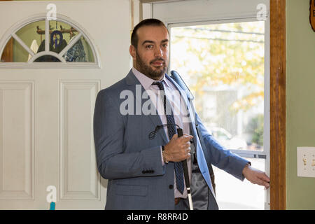 Businessman avec déficience visuelle allant dehors avec sa canne Banque D'Images