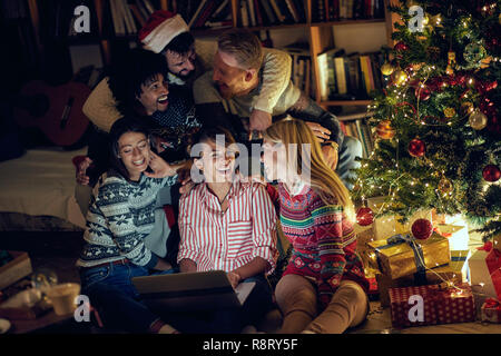 Happy friends watching movie on laptop la veille de Noël Banque D'Images