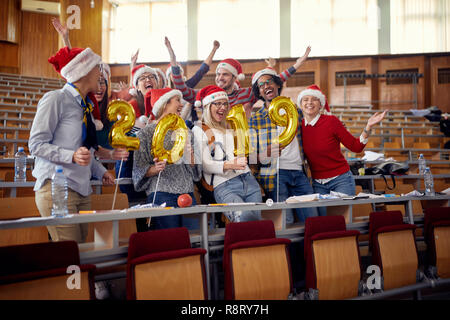 Groupe d'étudiants internationaux en souriant Santa hat célèbre maison de vacances Banque D'Images