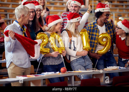 Smiling Students in Santa hat holding 2019 ballons d'or à la célébration du Nouvel An sur l'université Banque D'Images