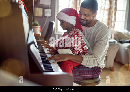 Jeune fille enfant avec le père Noël à jouer de la musique au piano. Banque D'Images