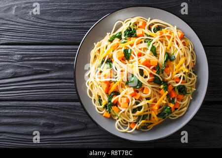 L'alph-spaghetti à la courge, épinards et fromage cheddar, close-up sur une plaque sur la table. haut horizontale Vue de dessus Banque D'Images