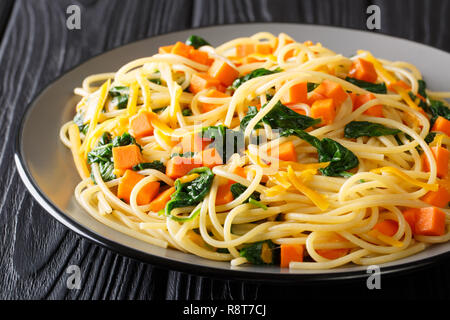 Déjeuner à faible teneur en calories de spaghetti avec du potiron, les épinards et le fromage cheddar close-up sur une plaque sur la table horizontale. Banque D'Images