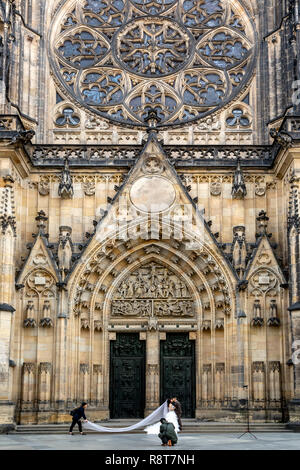 Mariée et le marié se faire photographier en face de l'église Saint-Guy, au Château de Prague, du château de quart, Prague, République Tchèque Banque D'Images