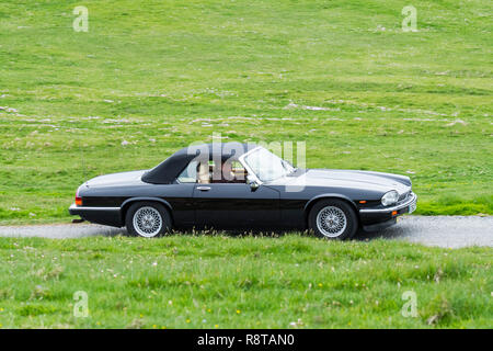 1988 Noir Jaguar XJ-S V12 convertible voiture de sport classique conduisant le long chemin à travers la prairie Banque D'Images