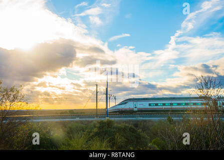 Train à grande vitesse voyageant au crépuscule. L'Espagne. Banque D'Images