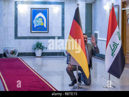 17 décembre 2018, l'Iraq, Bagdad : Avant la conférence de presse avec les ministres des affaires étrangères de l'Allemagne et l'Iraq, un technicien vous alignez les drapeaux des deux nations. Après l'Iraq Koweït Maas visites. Photo : Jens Büttner/dpa-Zentralbild/dpa Banque D'Images