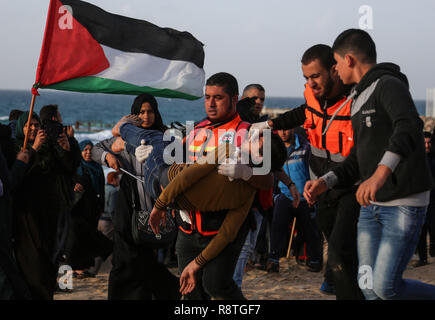 La bande de Gaza. 25Th Dec 2018. Un Palestinien médic transporte un homme blessé lors d'affrontements avec les troupes israéliennes sur une plage près de la frontière avec Israël dans le nord de la bande de Gaza, le 17 décembre 2018. Source : Xinhua/Alamy Live News Banque D'Images