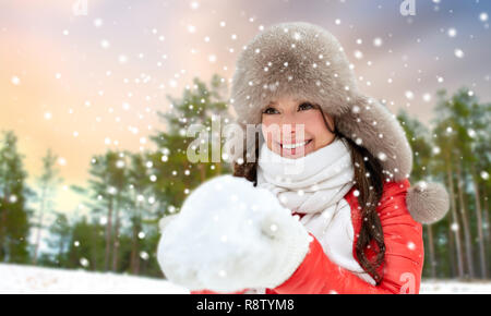 Femme au chapeau de fourrure avec de la neige en forêt d'hiver Banque D'Images