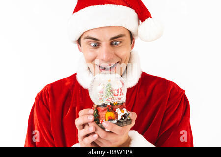 Image de l'homme excité 30s en costume de Père Noël et red hat holding Christmas ball isolé sur fond blanc en studio Banque D'Images