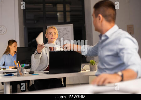 Documents donnant femme de collègue à l'office de nuit Banque D'Images