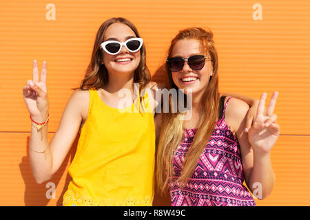 Smiling teenage girls montrant la paix en été Banque D'Images