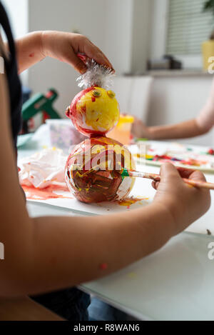 Bébé garçon s'amusant de faire un bonhomme de neige coloriage décorations de vacances qu'il a fait. Banque D'Images