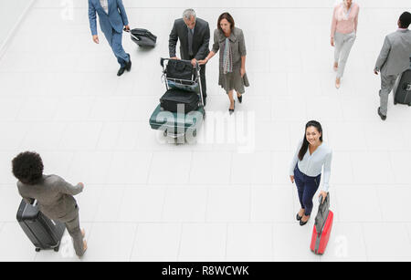 High angle portrait smiling businesswoman with suitcase in airport Banque D'Images