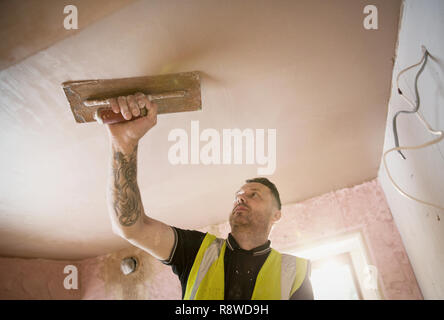 Construction Worker with tattoo plafond plâtre Banque D'Images