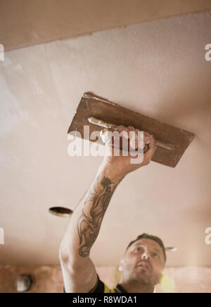 Construction Worker with tattoo plafond plâtre Banque D'Images