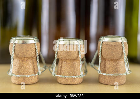 Bouchons de champagne sur une table en bois. Protections des fils et les bouchons après le Nouvel An. Fond clair. Banque D'Images