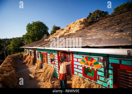 Femme indienne dans sa maison kumaoni tipycal, où un tas de blé est le séchage au soleil, Kala Agar Kumaon Hills village,, Uttarakhand, Inde Banque D'Images