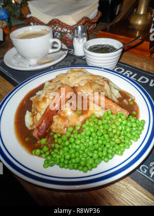 Saucisses traditionnelles et servi avec sauce purée d'oignon et les petits pois dans un pub anglais. Banque D'Images