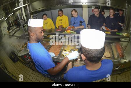 Océan Atlantique (11 mars 2017) - Airman Jonathan Hill et de l'Aviation l'Aviateur de Ordnanceman Duane Moore servent de la nourriture au cours d'après-midi chow dans l'office d'un navire d'assaut amphibie USS Iwo Jima (DG 7). Iwo Jima est en cours participant à une série de qualifications et certifications dans le cadre de la phase de la formation de base en préparation pour de futures opérations, et les mutations. Banque D'Images