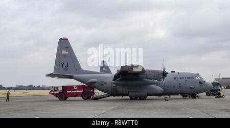 Aviateurs du 374e groupe d'opérations et 374e Escadron de génie civil, décharger un camion qui ont participé à l'exercice Cope North Guam à partir d'un C-130H Hercules 14 mars 2017, à Yokota Air Base, le Japon. Le camion a été utilisé pour fournir le support de ligne de vol au cours de l'exercice. Banque D'Images