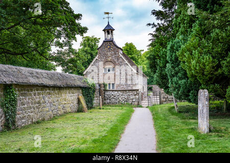 Une église en pierre historique et mur de chaume dans le village d'Avebury, Wiltshire, Angleterre, Europe. Banque D'Images