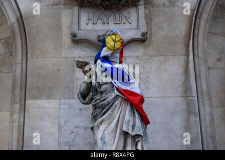 Les protestataires de jaune de démonstration (gilets jaunes) contre le gouvernement, et le président français mis gilet jaune et d'un drapeau sur Paris Opera Garnier Banque D'Images