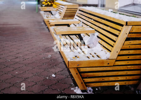 Bancs en bois brun à Noël en ville de nuit Banque D'Images