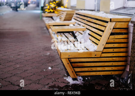 Bancs en bois brun à Noël en ville de nuit Banque D'Images