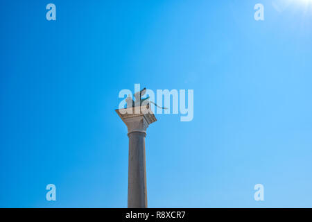 L'Europe. Venise. L'Italie. Lion de bronze sur une colonne de la place Saint Marc sur un fond bleu. Banque D'Images