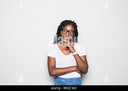 Les émotions humaines, les sentiments, la réaction et l'attitude. Jolie jeune fille en t-shirt et lunettes rondes serrant la main et en gardant les yeux sur le menton de doute Banque D'Images