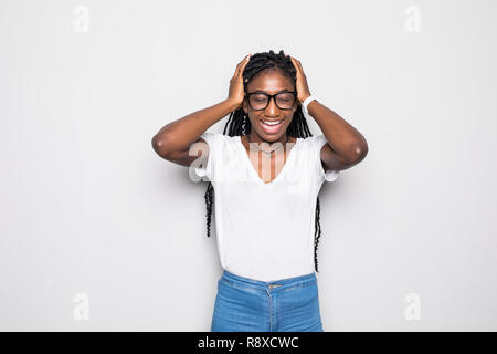 Jeune femme à la peau sombre en beige manches longues T-shirt froncer, ayant des expressions douloureuses, souffrant de graves maux de tête, mauvaise en gardant les yeux fermés, Banque D'Images