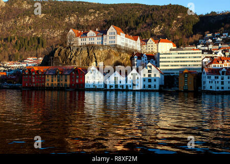 Skuteviken Skutevik (baie), avec de vieux bâtiments commerciaux en bois le long de la rive en face. Sur le dessus, Rothaugen middle school. Bergen, Norvège Banque D'Images