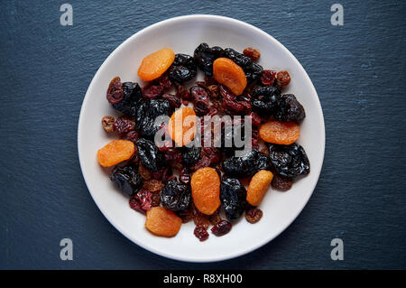Mélange de fruits séchés et les noix sur fond de bois. Les fruits sains. L'agriculture biologique et en bonne santé. Fruits secs, aliments colorés procédé sec Banque D'Images