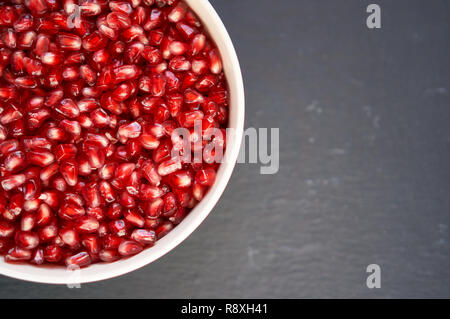 Graines de grenade rouge profond. Fruit de grenade. Grenadier sur fond sombre, photo horizontale. Banque D'Images