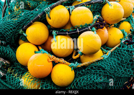 Tas de bouées de pêche jaune et vert filets de pêche, sur un quai dans le port de Bergen, Norvège Banque D'Images