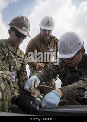 Bataillon de construction Mobile Marine marins 5 travailler avec une république de Corée (ROK) Bataillon de construction tout en reconstruisant un marin endommagé jetée à la Corée d'éducation et de formation de la marine commande dans Jinhae, Corée, le 14 mars 2017, dans le cadre de l'exercice Foal Eagle 2017. Foal Eagle est un exercice d'entraînement bilatéral annuel, conçu pour améliorer l'état de préparation des forces des États-Unis et de la République de Corée et de leur capacité à travailler ensemble durant une crise. Banque D'Images