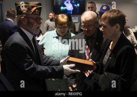 Dawna Duez, mère de l'U.S. Air Force Staff Sgt. Dylan Elchin, un contrôleur de combat tactiques spéciales avec le 26e Escadron tactique spéciale, est présenté un cadeau par un membre d'Anciens Combattants à l'étranger pendant un service commémoratif à Moon Township, Michigan, le 6 décembre 2018. Elchin a été tué aux côtés de deux membres des Forces spéciales de l'armée américaine lorsque leur véhicule a heurté un engin explosif improvisé dans la province de Ghazni, Afghanistan, le 27 novembre. Banque D'Images